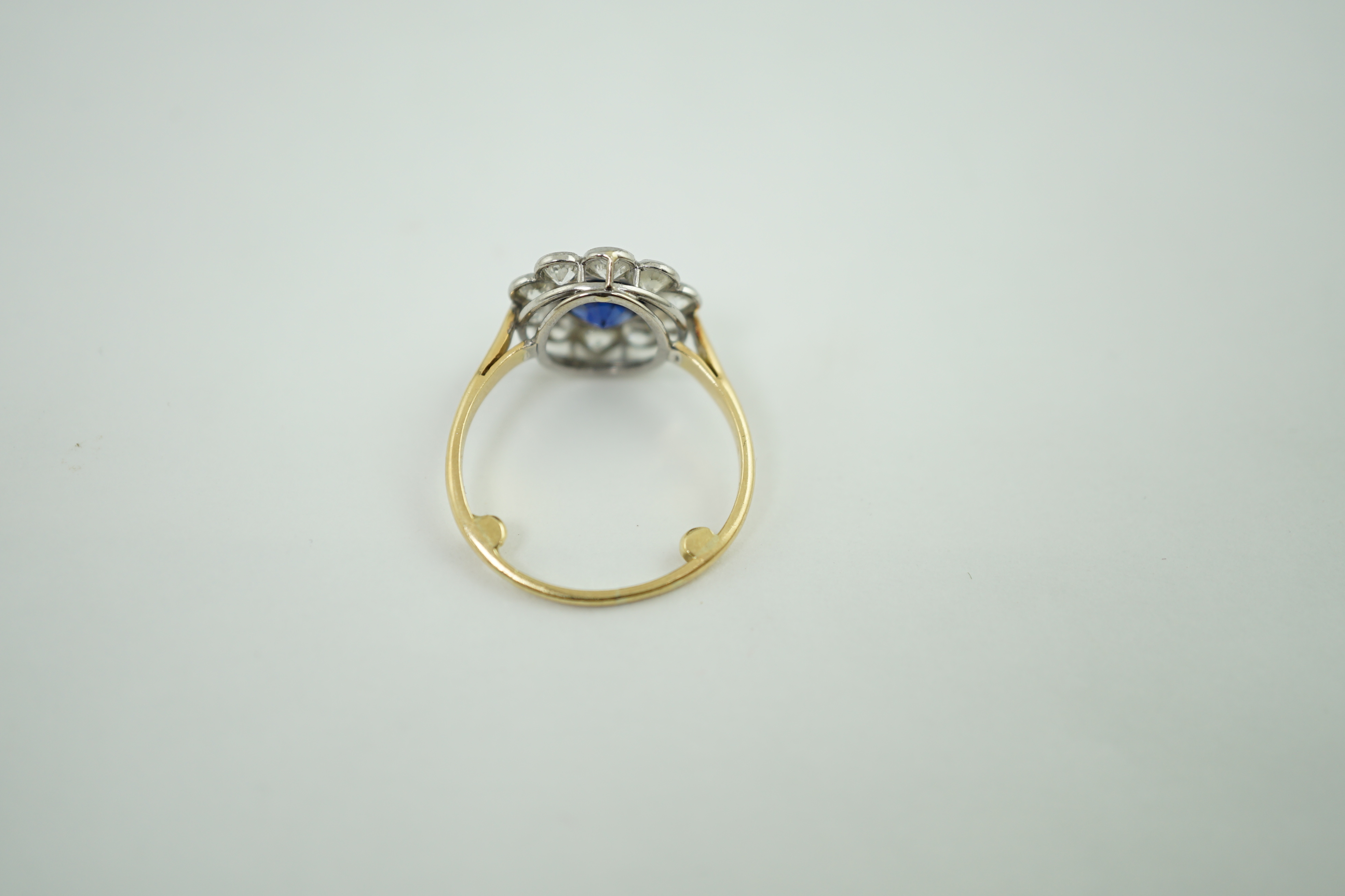 A mid 20th century gold, sapphire and millegrain set diamond flower head cluster ring